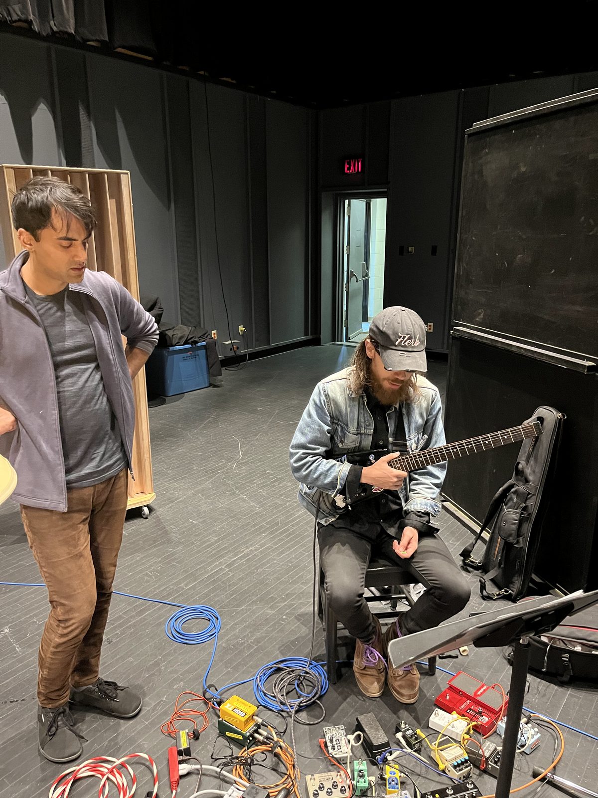 Musicians setting up guitar pedals in the studio